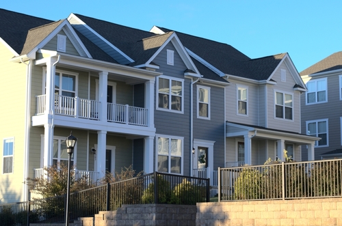 Multi-unit residential housing with front porches and fencing in suburban development